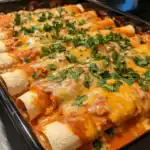 Delicious baked chicken enchiladas topped with melted cheese and fresh cilantro, perfect for family dinner or parties. Easy step-by-step recipe on Station Recipes.